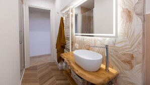 A modern bathroom with a large mirror, a wooden vanity, and a white sink. - Central  Romantic nest San Gimignano (San Gimignano)