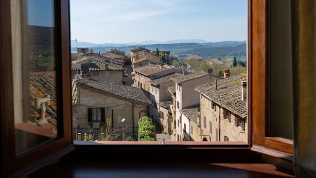 A view from a window overlooking a historic town with narrow streets and traditional architecture. - Central  Romantic nest San Gimignano (San Gimignano)