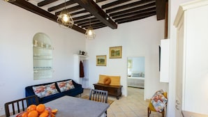 A cozy living room with a dining table, a sofa, and a chair. There is a bowl of oranges on the table. - Central  Romantic nest San Gimignano (San Gimignano)