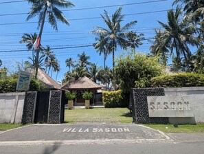 A gated entrance with 'Villa Sasoon' signage, a thatched-roof structure, and palm trees. - Villa Sasoon Beach 100m Full Services 250 Mbps (Samuh)