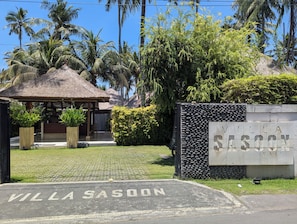 A villa entrance with a thatched roof, a stone wall, and a sign reading 'Villa Sasoon Bali'. - Villa Sasoon Beach 100m Full Services 250 Mbps (Samuh)