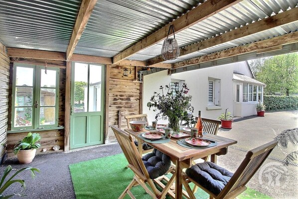 Un comedor rústico de madera con una mesa dispuesta para cuatro personas, rodeado de sillas de madera.