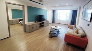 Un salon moderne avec un canapé, un téléviseur et une petite table ronde.