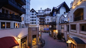 A narrow street lined with multi-story buildings featuring balconies and large windows, suggesting a historic or boutique hotel setting.