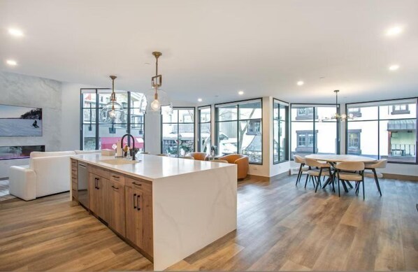 A modern kitchen with a large island, wooden cabinets, and pendant lighting. - Diamond-rated 2BR Condo in Heart of Vail Village - Center Place (Vail)