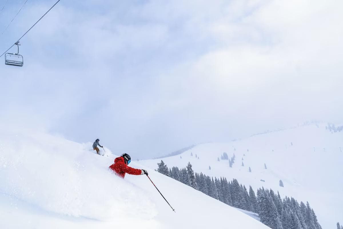 A ski slope with a person skiing down the hill.