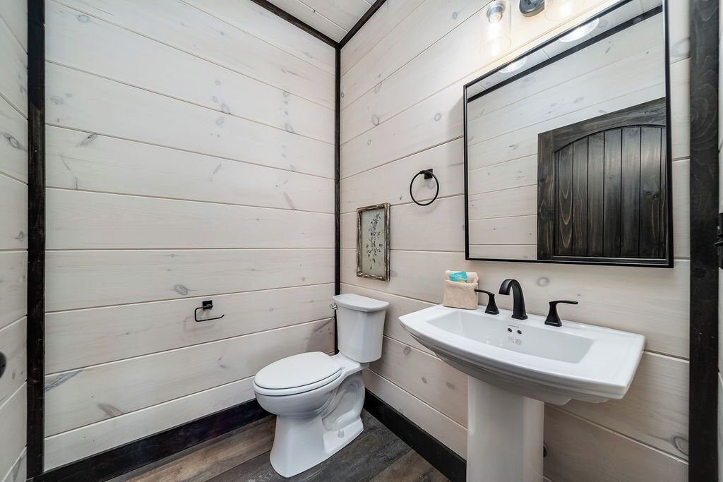 A bathroom with a white toilet, a sink, and a mirror.