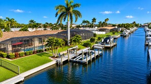 A marina with boats docked, a swimming pool, and a covered outdoor seating area.