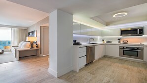 Una cucina moderna con forno Bosch, microonde e lavastoviglie. C'è un'area pranzo con divano e lampada. La stanza ha un'ampia finestra con vista sulla città.