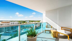 Un balcone con vista su una piscina e edifici circostanti.