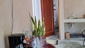 Une cuisine avec un plan de travail en bois, une machine à café, un évier et une plante en pot.