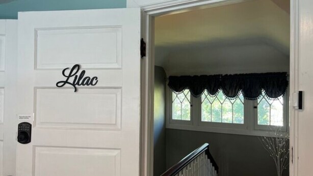 Puerta blanca con el nombre "Lilac" y un teclado electrónico.