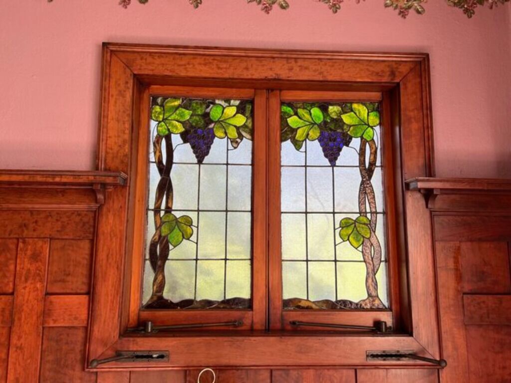 A stained glass window with grapevines and leaves.