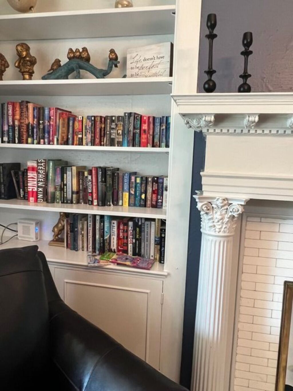 Una habitació amb una llar de foc, una biblioteca plena de llibres i objectes decoratius.