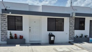 A modern two-story building with a white facade and stone accents.