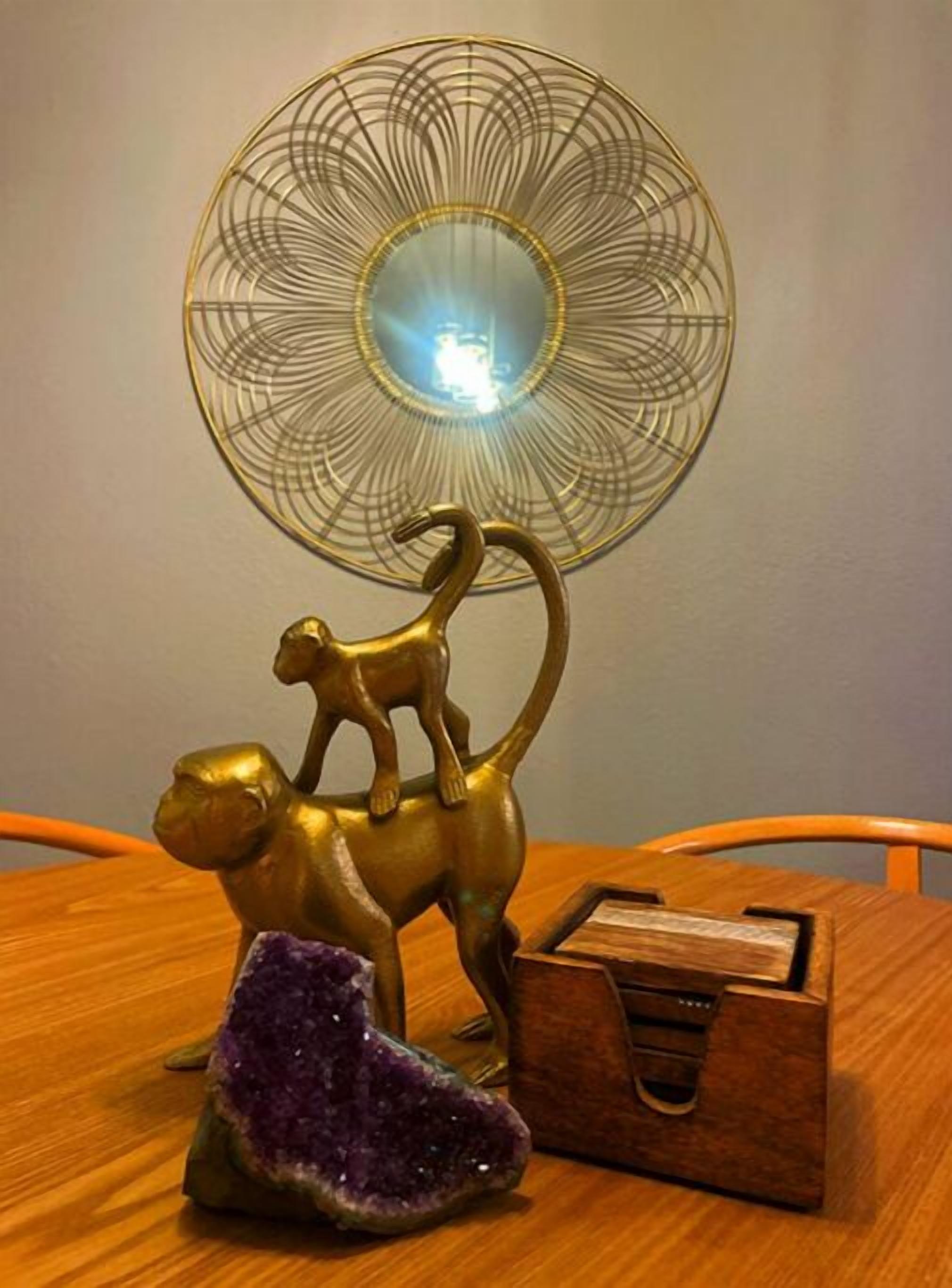 A wooden table with a brass statue of a dog on a rock, a purple crystal, and a wooden box.