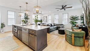 A modern kitchen with a central island, stainless steel appliances, and pendant lighting. - The Highline - Downtown Rooftop Escape (Columbus)