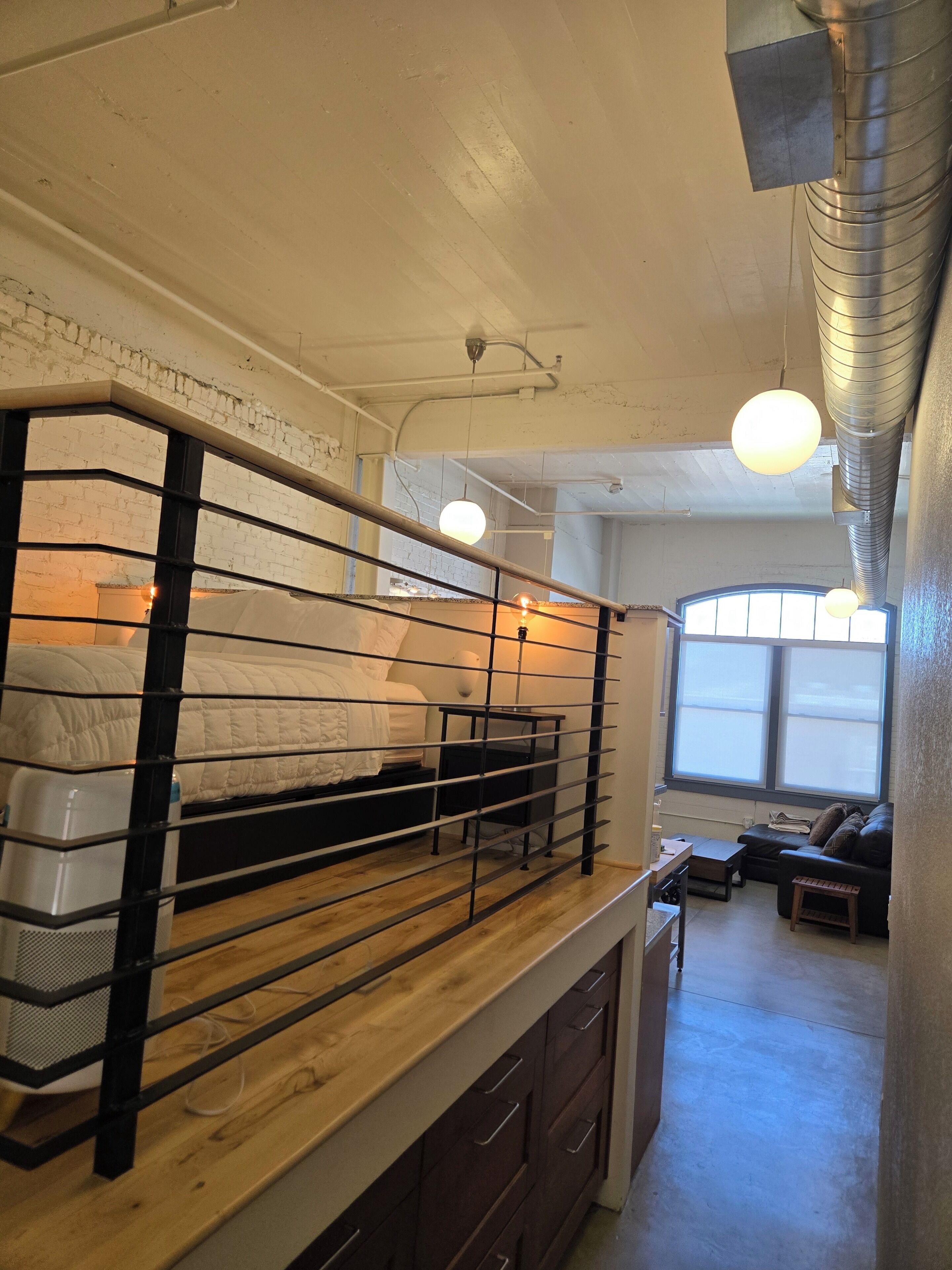 A room with a bunk bed, a desk, and a window.