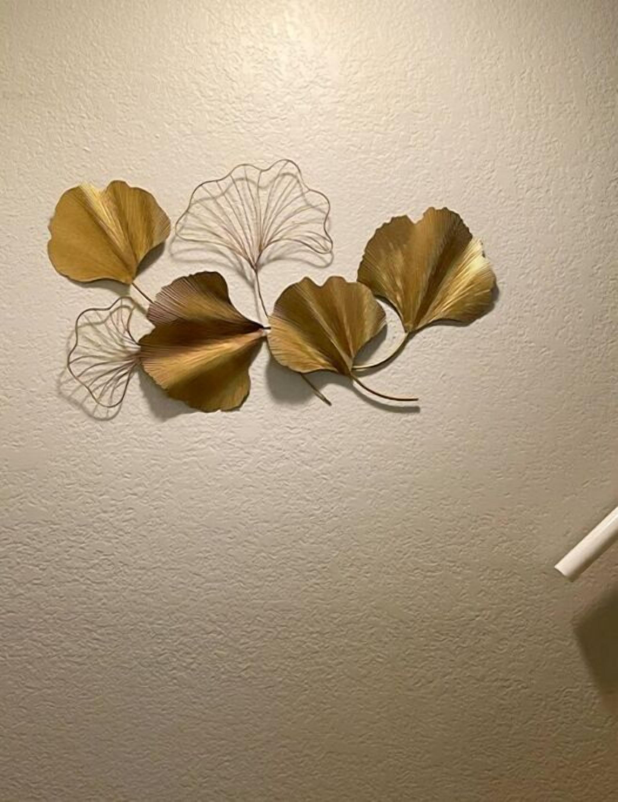 A wall with a decorative metal leaf design.