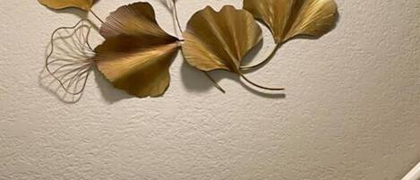 A wall with a decorative metal leaf design.