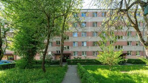 Ein mehrstöckiges Wohngebäude mit einem gepflasterten Weg, der zum Eingang führt.
