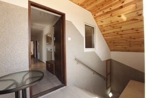 Contemporary space with a glass table, wooden door, and tiled floor.