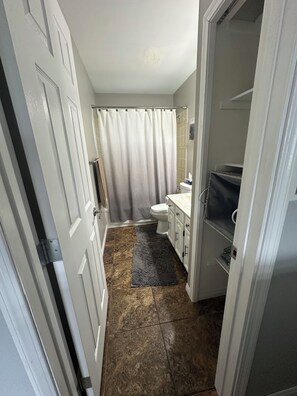 Une petite salle de bain comprenant des toilettes, un lavabo et un rideau de douche.