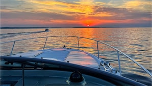 A boat's bow with a view of a sunset over calm water. - Coastal Living in the heart of St. Ignace. (St. Ignace)