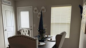 A dining room with a wooden table, four chairs, and a decorative centerpiece. - Welcome to your home away from home! Our charming 4 bedroom home (Alexander)