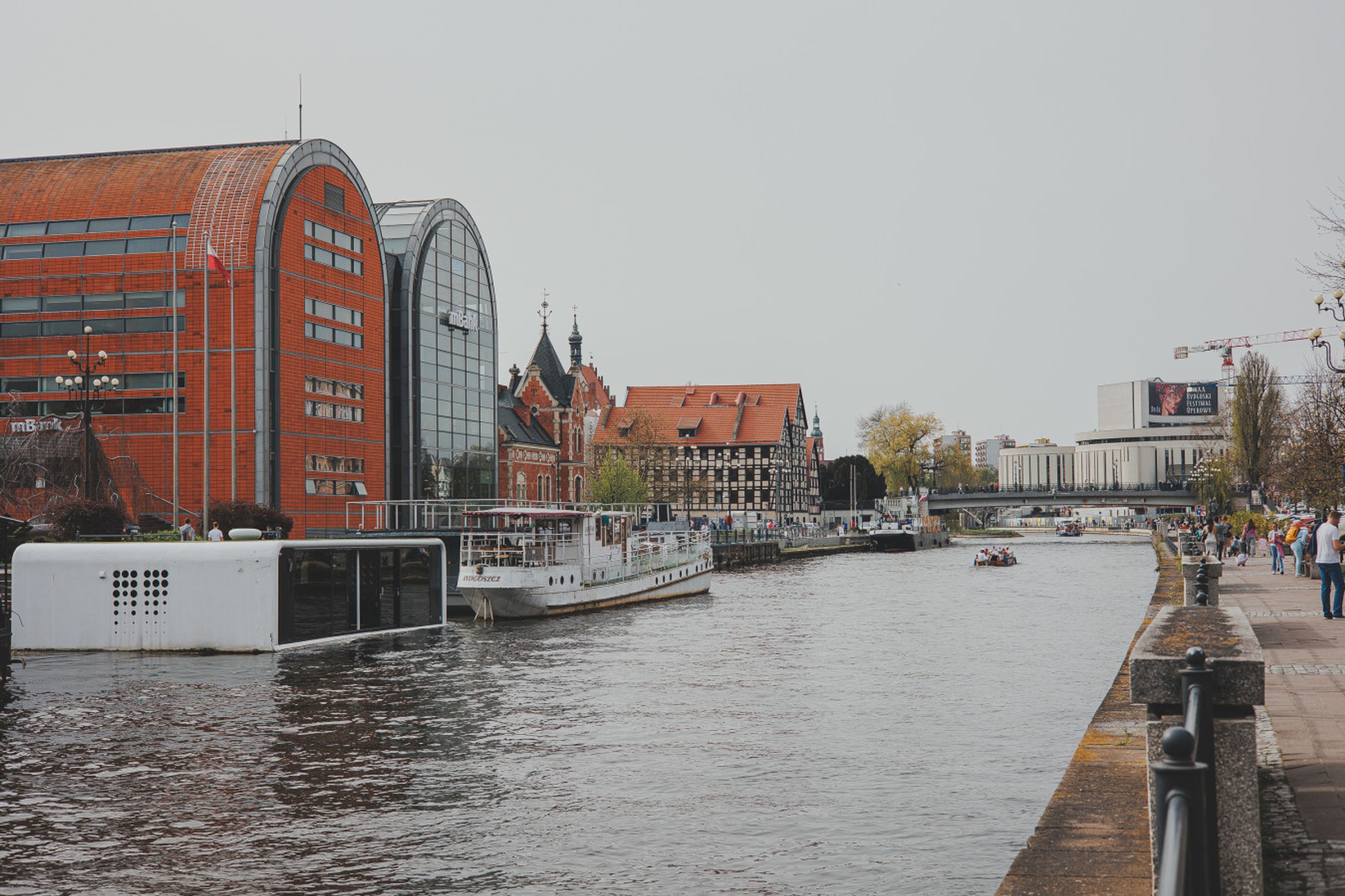 A river with boats, a bridge, and buildings along the riverbank.
