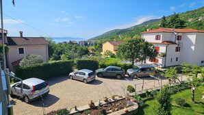 Un quartier résidentiel avec des maisons, des voitures garées et une vue dégagée sur les collines environnantes.
