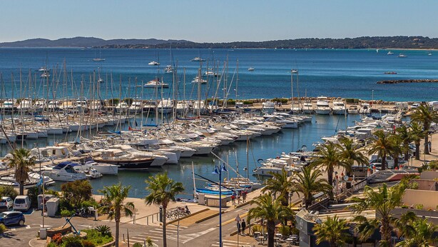 A marina with numerous boats docked, palm trees, and a clear view of the sea. - Les Astérides by Interhome (Hyères)