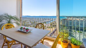 A balcony with a table, chairs, and potted plants. - Les Astérides by Interhome (Hyères)