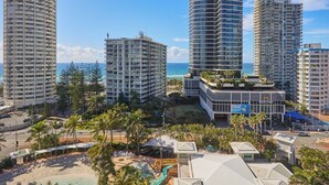 Ein Hotelkomplex mit mehreren Hochhäusern, einem Poolbereich und Blick auf den Strand.
