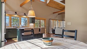 Una cocina amplia con vigas de madera, ventanas grandes y una isla central.