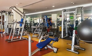 Un gimnasio con diverso equipo de ejercicio, incluyendo máquinas de pesas y pesas libres.