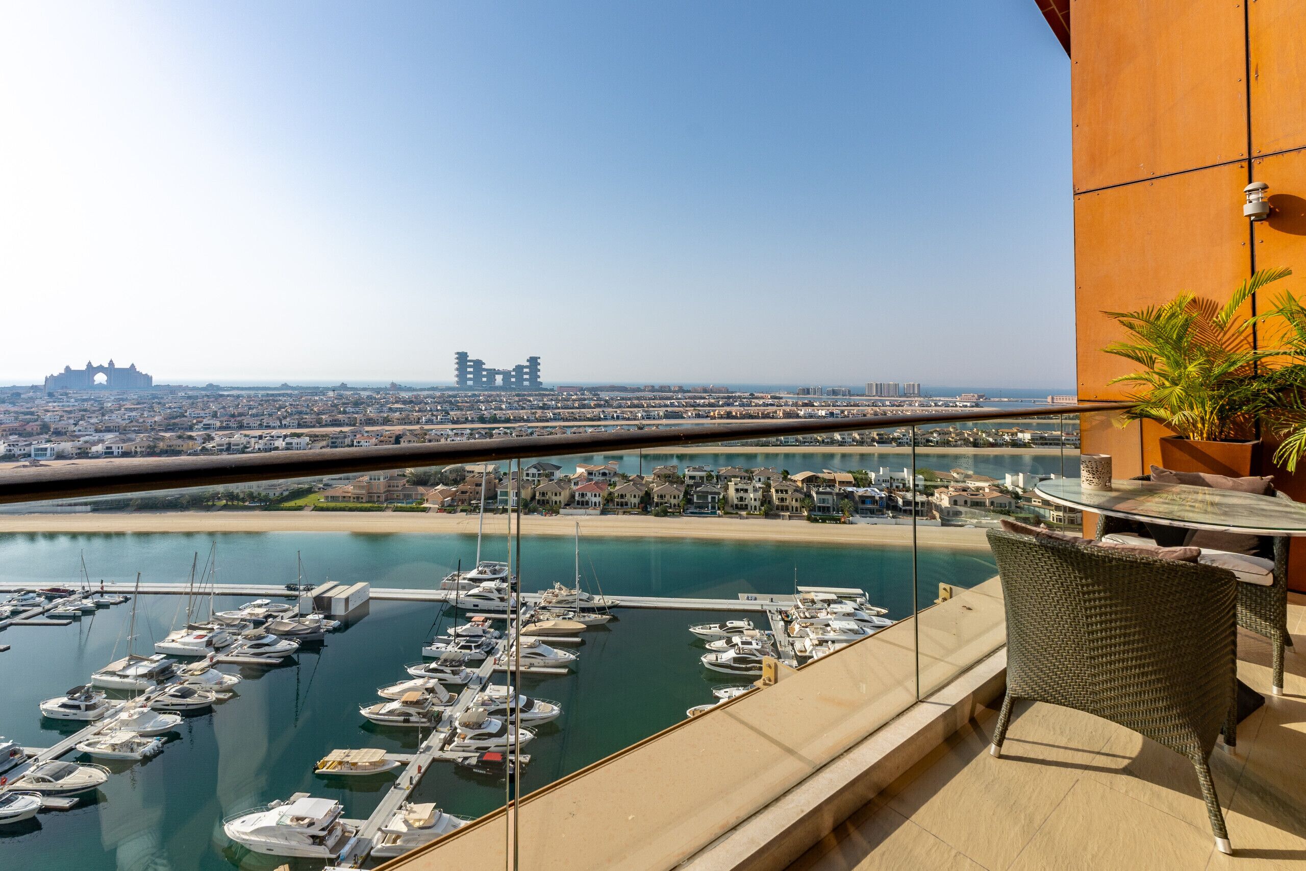 A balcony with a view of a marina and cityscape.