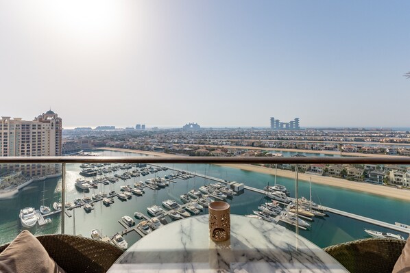 A high-rise hotel room with a view of a marina and cityscape.