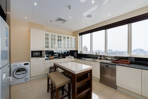A modern kitchen with a large island, built-in appliances, and a view of the city.