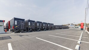 Ein Parkplatz mit Reihen von Versandcontainern und einem Gebäude im Hintergrund.