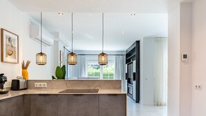 A modern kitchen with a marble countertop, pendant lights, and a view to the dining area. - Peaceful Lux, 3 Bed townhouse 10 min to the Beach REF016 (Mijas Costa)