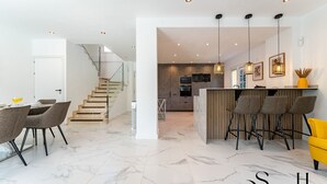 A modern kitchen with a central island, bar stools, and pendant lighting. - Peaceful Lux, 3 Bed townhouse 10 min to the Beach REF016 (Mijas Costa)