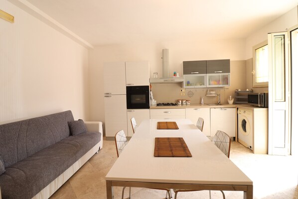 Une cuisine moderne avec une table à manger, un canapé et un lave-linge.