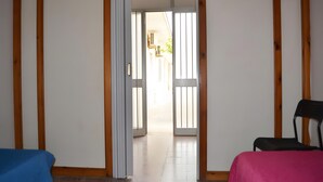 A room with a bed, a chair, and a door leading to an outdoor area.