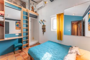 A bedroom with a bunk bed, a bedside table, a window with curtains, and a wall-mounted mirror. - Apartment 'En Plein Centre D'Avignon' with Wi-Fi and Air Conditioning (Avignon)