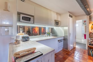 A modern kitchen with white cabinets, a microwave, a toaster, and a sink. - Apartment 'En Plein Centre D'Avignon' with Wi-Fi and Air Conditioning (Avignon)