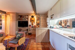 A modern kitchen with a central island, built-in appliances, and a dining area with a sofa and chairs. - Apartment 'En Plein Centre D'Avignon' with Wi-Fi and Air Conditioning (Avignon)