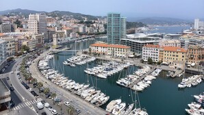 A marina with numerous boats docked, surrounded by buildings and a clear sky. - Cruise Apartment with Private Terrace, Balcony, and Wi-Fi (Savona)