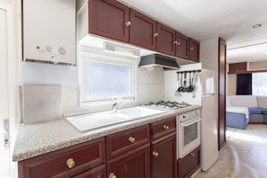 A compact kitchen with a window, built-in oven, and a stove.