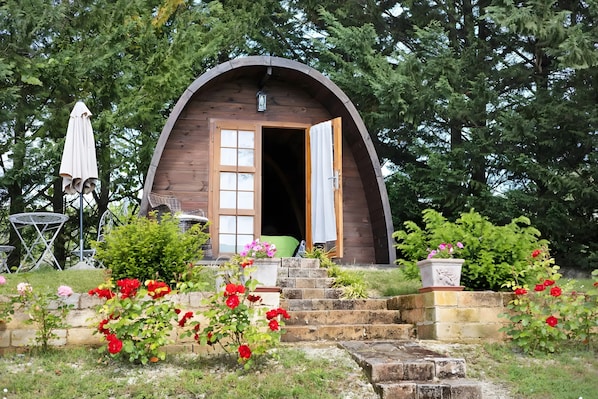 A wooden structure with a semi-circular roof, a door, and steps leading up to it.
